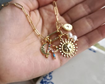 Collar con cierre de mosquetón dorado, inicial arcoíris, dije de sol, luna y estrella, perla de agua dulce.