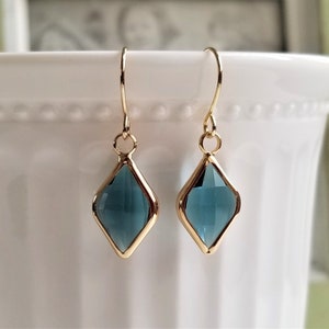 Puede incluir: Un par de pendientes de oro con colgantes en forma de lágrima de piedra preciosa azul.