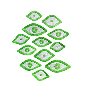 May include: A collection of green and white eye-shaped patches with a textured surface. The patches are arranged in a diamond shape.