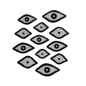 May include: A set of ten black and white eye-shaped patches. The patches are arranged in a pyramid shape, with the largest patch at the top and the smallest patches at the bottom.