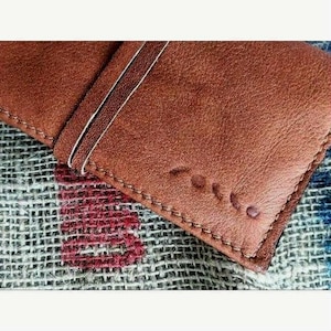 Porta tabacco in pelle color cuoio, chiusura con laccio. Tasche per filtri, cartine e accendino