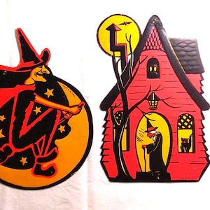 May include: Two vintage-style cardboard Halloween decorations. One is a circular cutout of a witch flying on a broomstick against an orange moon. The other is a house-shaped cutout featuring a red house, a yellow moon, a witch, and a black cat.