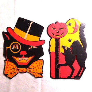 May include: Two vintage-style Halloween paper cutouts. The first is a black cat wearing a top hat, monocle, and orange polka-dot bow tie. The second features a red jack-o'-lantern, a yellow crescent moon with a face, and a black arched cat.