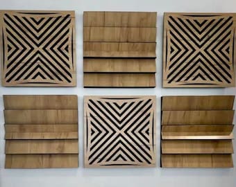 May include: Six square wooden wall art panels. Two panels feature a geometric design with black lines, while the other four have a layered, horizontal slat design. The panels are mounted on a white wall.