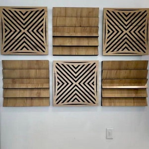 May include: Six wooden wall panels with geometric designs. The panels are arranged in a grid pattern on a white wall. The panels are all the same size and shape, but they have different designs. Some of the panels have a simple geometric design, while others have a more complex design.