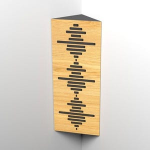 Op de afbeelding: Een houten hoekluidspreker met een zwarte bovenkant en een geluidsgolfontwerp. De luidspreker is gemaakt van lichtgekleurd hout en heeft een reeks horizontale zwarte lijnen die in een golfpatroon zijn gerangschikt. De luidspreker is in de hoek van een kamer gemonteerd.
