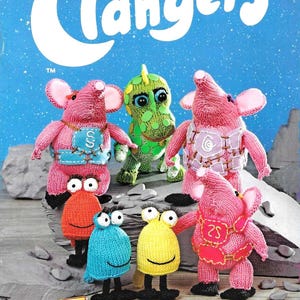 May include: A book cover with the title "Knit your own Clangers" in white letters on a blue background. The image features several knitted Clangers characters in pink, green, orange, blue, and yellow. The cover also includes the text "7 simple patterns + easy-to-follow instructions."