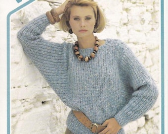 May include: A light blue knit sweater with a wide neckline and long sleeves. The sweater is paired with a brown belt and khaki pants. The image also includes the text "Wendy" and "Donna". The sweater's chest measurement is 30-40 inches.