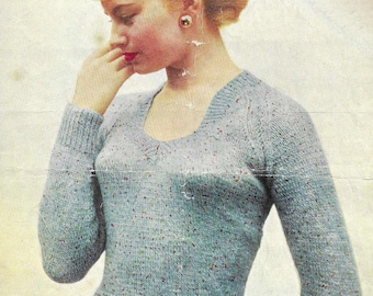 May include: A vintage-style image of a woman wearing a light blue knitted sweater with a scoop neckline and long sleeves. The sweater has a speckled pattern. She is wearing red lipstick and a red skirt. The background is a faded cream color.