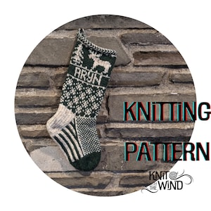 Peut inclure: Modèle de tricot pour une chaussette de Noël verte et blanche avec un motif de renne et le nom "Aryn" tricoté dans la chaussette. La chaussette est accrochée à un mur de briques. Le modèle est de "Knit With The Wind".