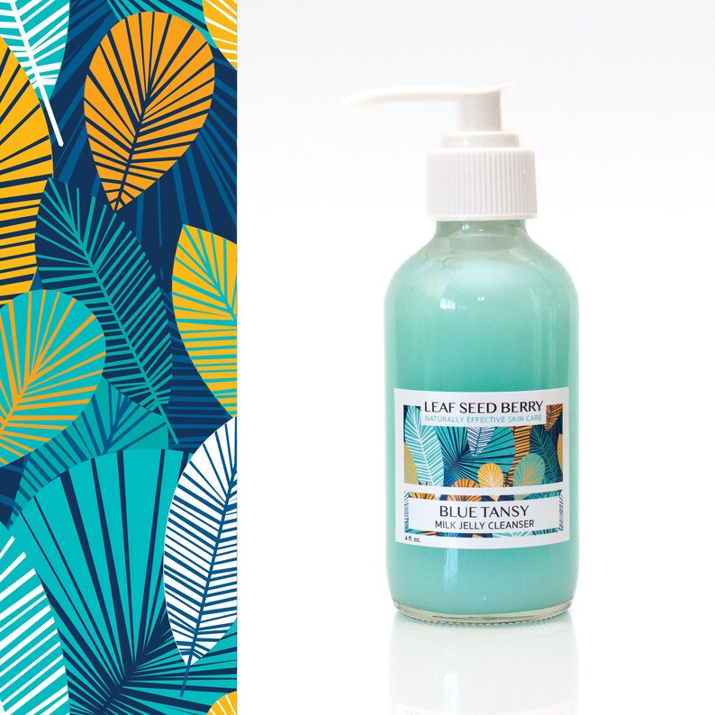 May include: A blue bottle of Blue Tansy Milk Jelly Cleanser by Leaf Seed Berry, a naturally effective skin care brand. The bottle has a white pump top and a label with a tropical leaf design.