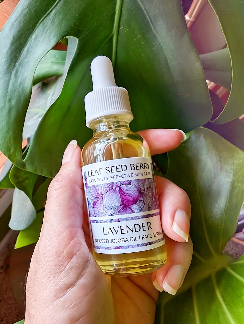 May include: A glass bottle of lavender infused jojoba oil face serum. The bottle is labeled "Leaf Seed Berry Naturally Effective Skin Care" and "Lavender Infused Jojoba Oil | Face Serum".