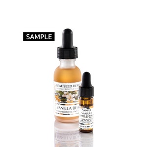 May include: Two glass bottles with dropper tops, one larger than the other. The larger bottle is filled with a light amber liquid and has a label that reads "LEAF SEED BERRY NATURALLY EFFECTIVE SKIN CARE VANILLA BEAN INFUSED JOJOBA OIL | FACE | BODY". The smaller bottle is filled with a darker amber liquid and has a label that reads "SAMPLE VANILLA BEAN INFUSED JOJOBA OIL 5 drops of oil can be used to moisturize, soften, and revitalize skin. LEAF SEED BERRY SKIN CARE".