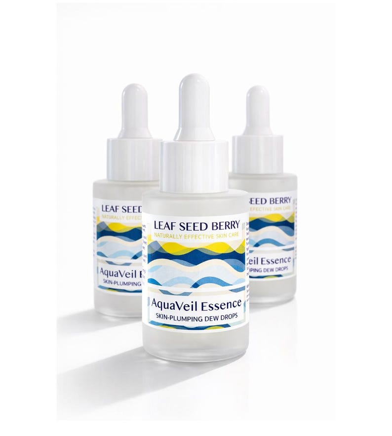 May include: Three clear glass dropper bottles of AquaVeil Essence skin-plumping dew drops. Each bottle has a white cap and a label with blue, yellow, and white wave designs. The text "LEAF SEED BERRY" and "AquaVeil Essence" are visible on the labels.