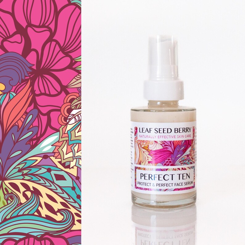 May include: A clear glass bottle with a white pump top, containing a beige liquid. The label reads "LEAF SEED BERRY" and "PERFECT TEN". The background features a colorful floral pattern in pink, orange, and teal.