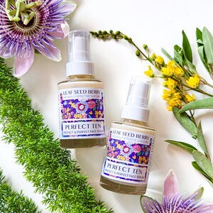 May include: Two glass bottles of face serum with a floral design. The bottles are labeled "Leaf Seed Berry Naturally Effective Skin Care Perfect Ten Protect & Perfect Face Serum".