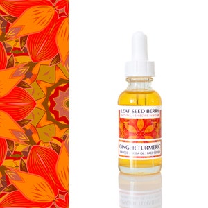 May include: A clear glass bottle with a white dropper filled with yellow liquid. The label reads "LEAF SEED BERRY" and "GINGER TURMERIC" with the text "INFUSED JOJOBA OIL | FACE SERUM". The background features a colorful floral pattern in shades of orange and brown.