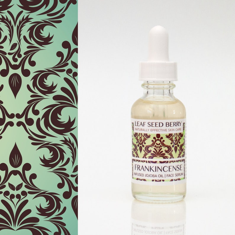 May include: A clear glass bottle with a white dropper top and a label that reads "Leaf Seed Berry Naturally Effective Skin Care Frankincense Infused Jojoba Oil | Face Serum".