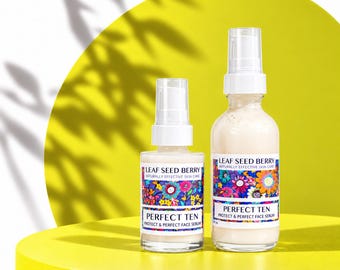 May include: Two clear glass pump bottles of Leaf Seed Berry Perfect Ten Protect & Perfect Face Serum. Each bottle features a white label with a colorful floral pattern, black text, and a white pump dispenser top containing a beige liquid.