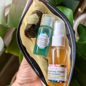 May include: Three small bottles of skincare products in a white zippered pouch. The bottles are labeled "Sample" and contain a gel cleanser, a milk jelly cleanser, and a exfoliating toner rose essence. All three bottles are from the brand Leaf Seed Berry Skincare.