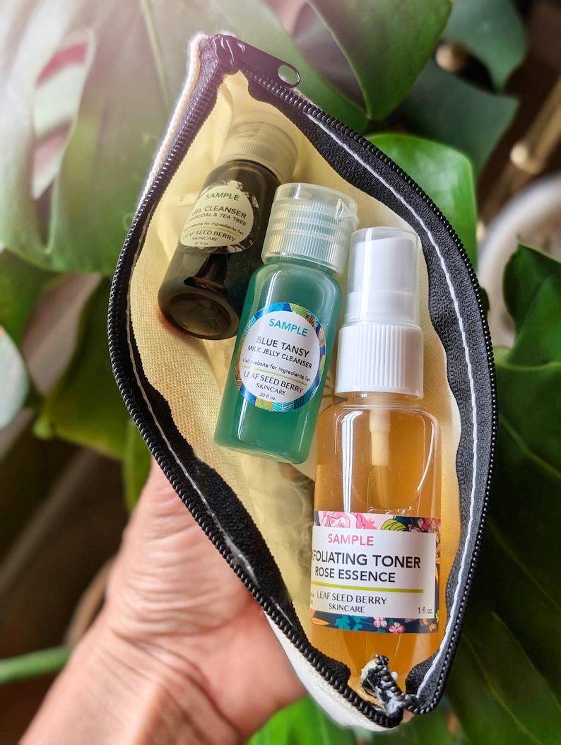 May include: Three small bottles of skincare products in a white zippered pouch. The bottles are labeled "Sample" and contain a gel cleanser, a milk jelly cleanser, and a exfoliating toner rose essence. All three bottles are from the brand Leaf Seed Berry Skincare.
