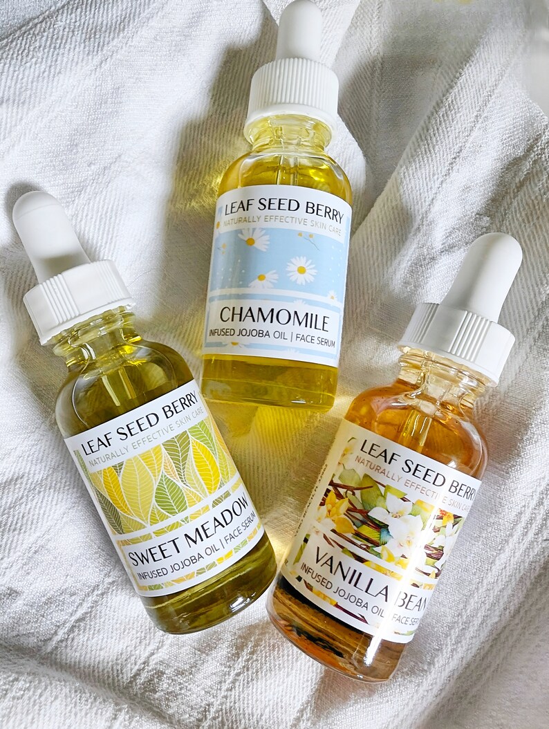 May include: Three glass bottles of face serum with dropper tops. The bottles are labeled with the brand name "Leaf Seed Berry" and the scents "Chamomile", "Sweet Meadow", and "Vanilla Bean".