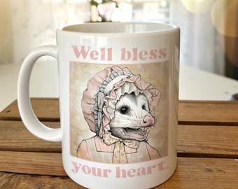 Taza de cerámica "Bendice tu corazón". Regalo para amantes de las zarigüeyas. Taza de café con ilustraciones de zarigüeyas campestres. Chica pionera con estilo cottagecore sureño.