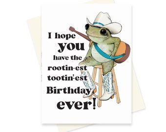 May include: A green frog wearing a cowboy hat and boots, holding a guitar, sits on a stool. The text reads "I hope you have the rootin'-est tootin'-est Birthday ever!"