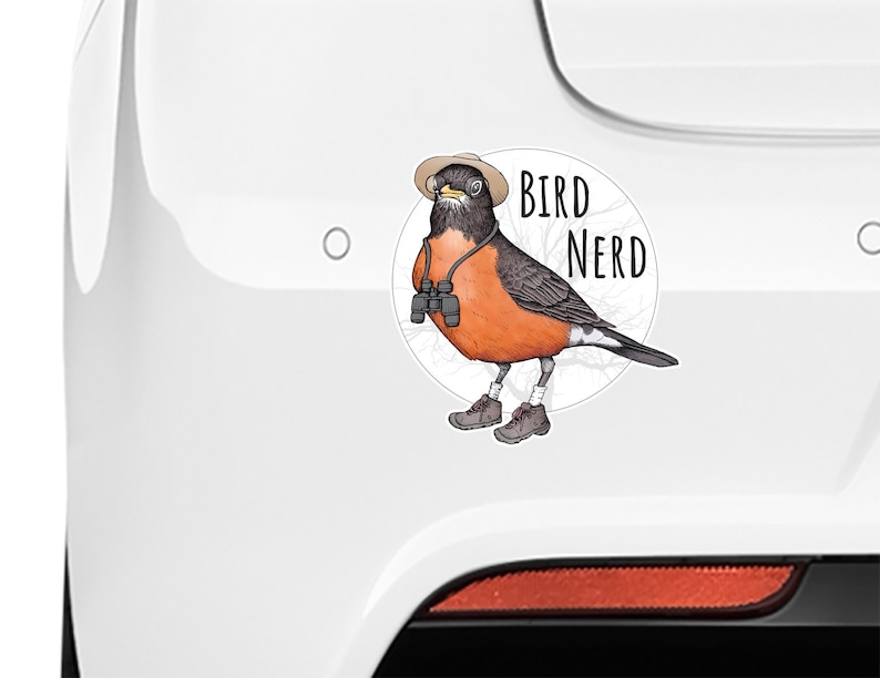 May include: A white car with a sticker of a cartoon robin wearing a hat, glasses, and binoculars. The sticker says "Bird Nerd".