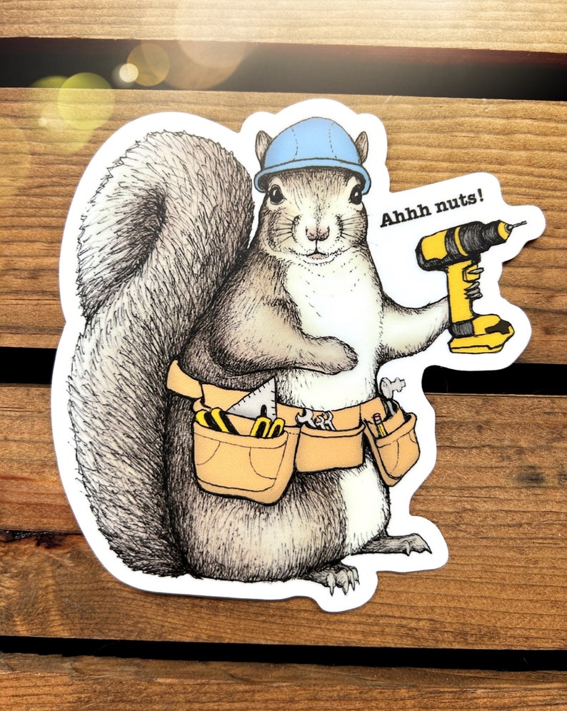 Peut inclure: Un &eacute;cureuil de dessin anim&eacute; portant un casque bleu et une ceinture &agrave; outils avec une perceuse dans sa main. L'&eacute;cureuil dit "Ahhh nuts!"