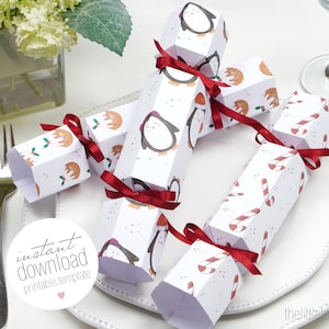 Op de afbeelding: Witte zeshoekige kerstcrackers met rode strikken. De crackers zijn versierd met pinguïn-, vos- en zuurstokpatronen. De tekst "instant download printable template" is zichtbaar in de afbeelding.