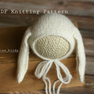 May include: White knitted bunny hat with long ears and a tie. PDF Knitting Pattern. three.birds