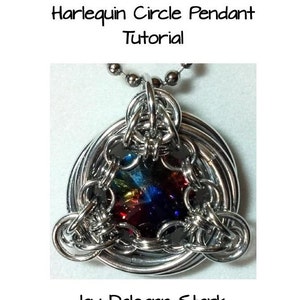 Puede incluir: Un collar de cadena de plata con un colgante con un diseño circular con una piedra preciosa multicolor en el centro. El colgante está hecho de anillos de metal entrelazados. El colgante es un colgante círculo Harlequin.