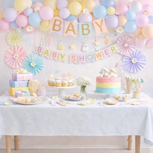 Op de afbeelding: Een babyshower-opstelling met een pastelkleurige ballonnenboog, banners met de tekst BABY en BABY SHOWER, papieren waaiers, een taart, cupcakes en geschenkdozen op een wit tafelkleed. De decoratie bevat gele, blauwe, roze en paarse accenten.