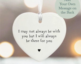 May include: White ceramic heart ornament with the text "I may not always be with you but I will always be there for you".  The ornament has a ribbon for hanging and a space on the back for a personalized message.