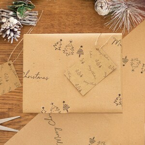 May include: Brown paper gift wrap with a repeating pattern of small Christmas trees and stars. The paper is wrapped around a box with a tag that says "Merry Christmas".