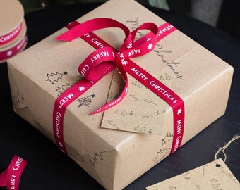 May include: A brown paper gift box wrapped with red ribbon that says "Merry Christmas" in white lettering. The box is tied with a bow and has a small gift tag attached.