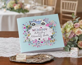 May include: A light blue wedding activity and colouring book featuring colourful hand-drawn illustrations of a vintage car, a tiered cake, balloons, hearts, and top hats, with the text Wedding Activity and Colouring Book printed on the front cover.