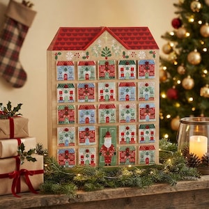 May include: A wooden house-shaped advent calendar with a red roof and twenty-four numbered drawers. Each drawer features a colorful illustration of a small house, with one drawer depicting a Santa Claus figure. The calendar has a natural wood finish.