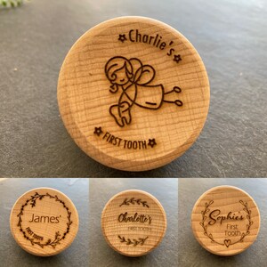 May include: Three wooden tooth fairy boxes with different designs. The first box has a tooth fairy illustration and the text "Charlie's" and "First Tooth". The second box has a floral wreath design and the text "James'" and "First Tooth". The third box has a floral wreath design and the text "Charlotte's" and "First Tooth".