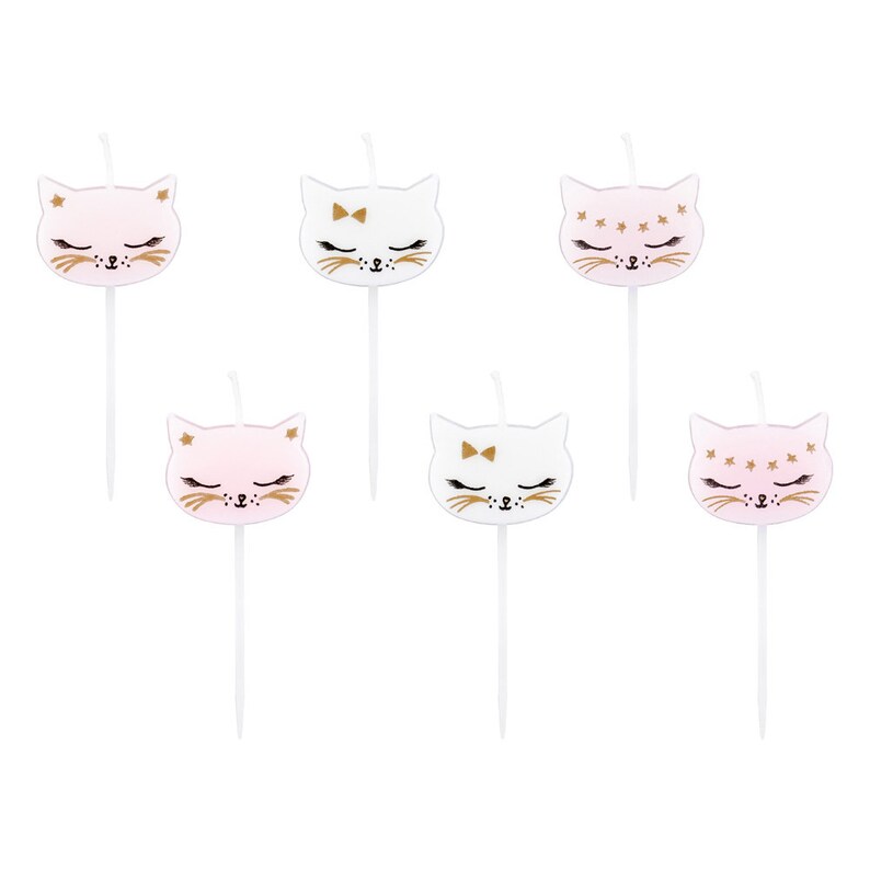 May include: Six pink and white cat-shaped candles with gold accents. The candles have different designs, including a bow, stars, and closed eyes.