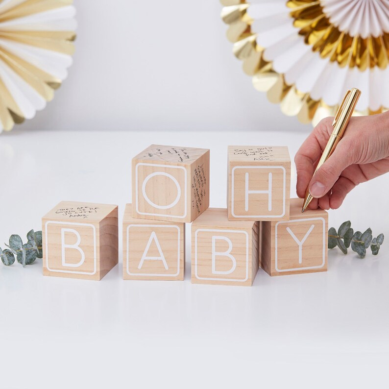 May include: Wooden blocks spelling "OH BABY" with white lettering. Each block has a blank surface for guests to write messages.