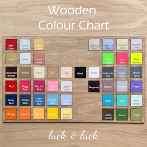 Puede incluir: Carta de colores de madera con una variedad de colores, incluyendo rojo, azul, verde, amarillo, rosa y negro. La carta est&aacute; etiquetada como "Wooden Color Chart" y "luck & luck".