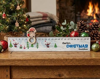 Könnte beinhalten: Ein rechteckiges hölzernes Weihnachts-Countdown-Schild mit einer nummerierten Skala von 1 bis 25, verziert mit grünen Bäumen und roten Geschenken. Es enthält einen beweglichen Wichtel-Marker aus Holz und den Text Charlie's CHRISTMAS Countdown.