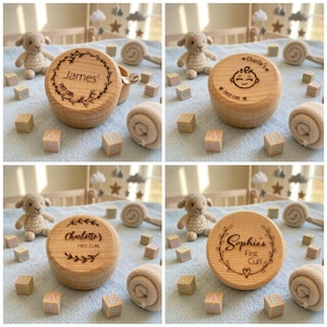 May include: Four round wooden keepsake boxes for baby hair curls, each featuring laser-engraved names like James, Charlie, Charlotte, or Sophie, along with decorative floral wreaths, stars, or a smiling face icon, surrounded by small wooden blocks.