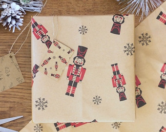 May include: Brown wrapping paper with a repeating pattern of nutcracker soldiers and snowflakes. The nutcracker soldiers are wearing red and black uniforms with white accents. The snowflakes are black.