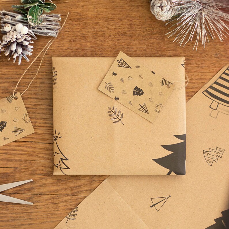 May include: A brown paper gift bag with a black and white tree design. The bag is decorated with a small tag that has a black and white tree design and the words "Merry Christmas".