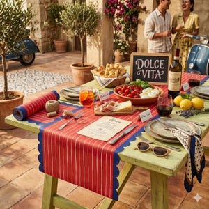 May include: A table set for an outdoor meal with a red and white striped table runner. The table is set with plates, glasses, food, and a chalkboard sign that says "Dolce Vita". A bottle of wine and lemons are also on the table.