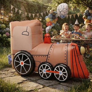 May include: An inflatable train toy in shades of tan, orange, and black, featuring a large cab, a cylindrical boiler, and black wheels with white spokes. The front of the train has a red cowcatcher and a light-coloured headlight detail.