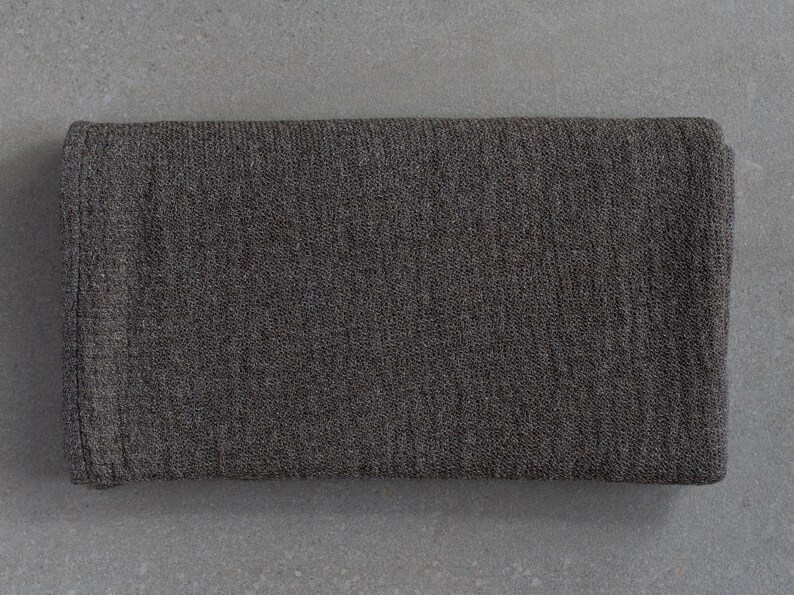 May include: A dark gray knitted fabric with a textured surface.